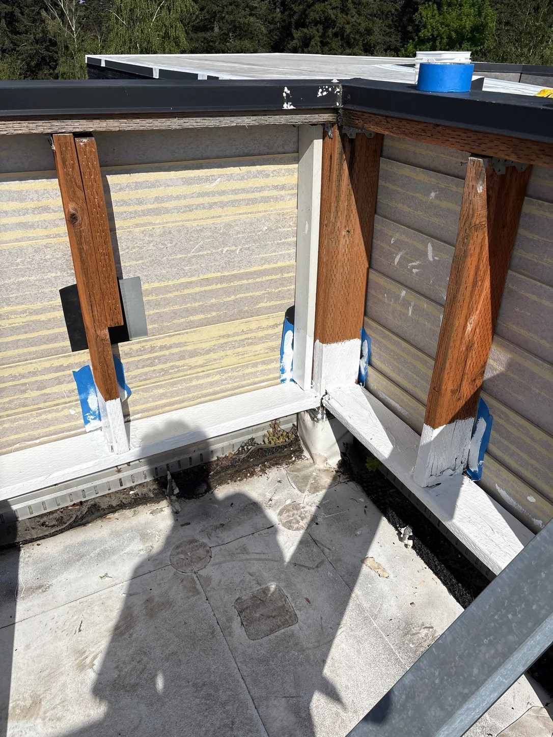 Wooden posts coated with white silicone where they meet the roof.