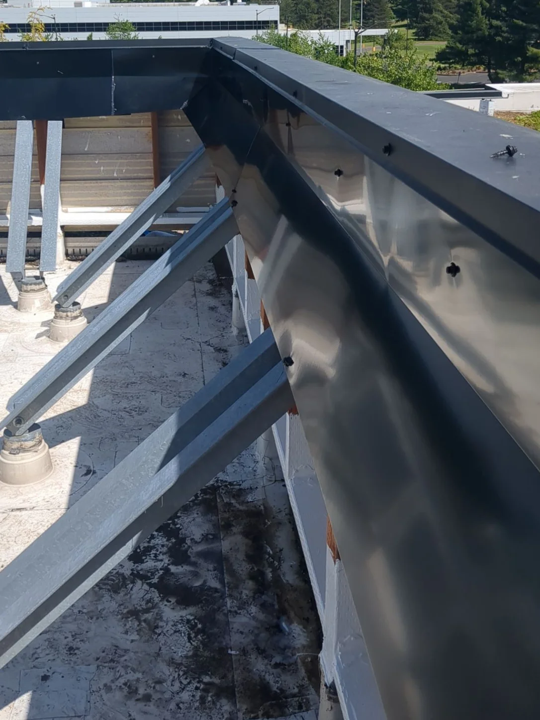 A custom metal cap fitted over the steel framing at the roof's edge.