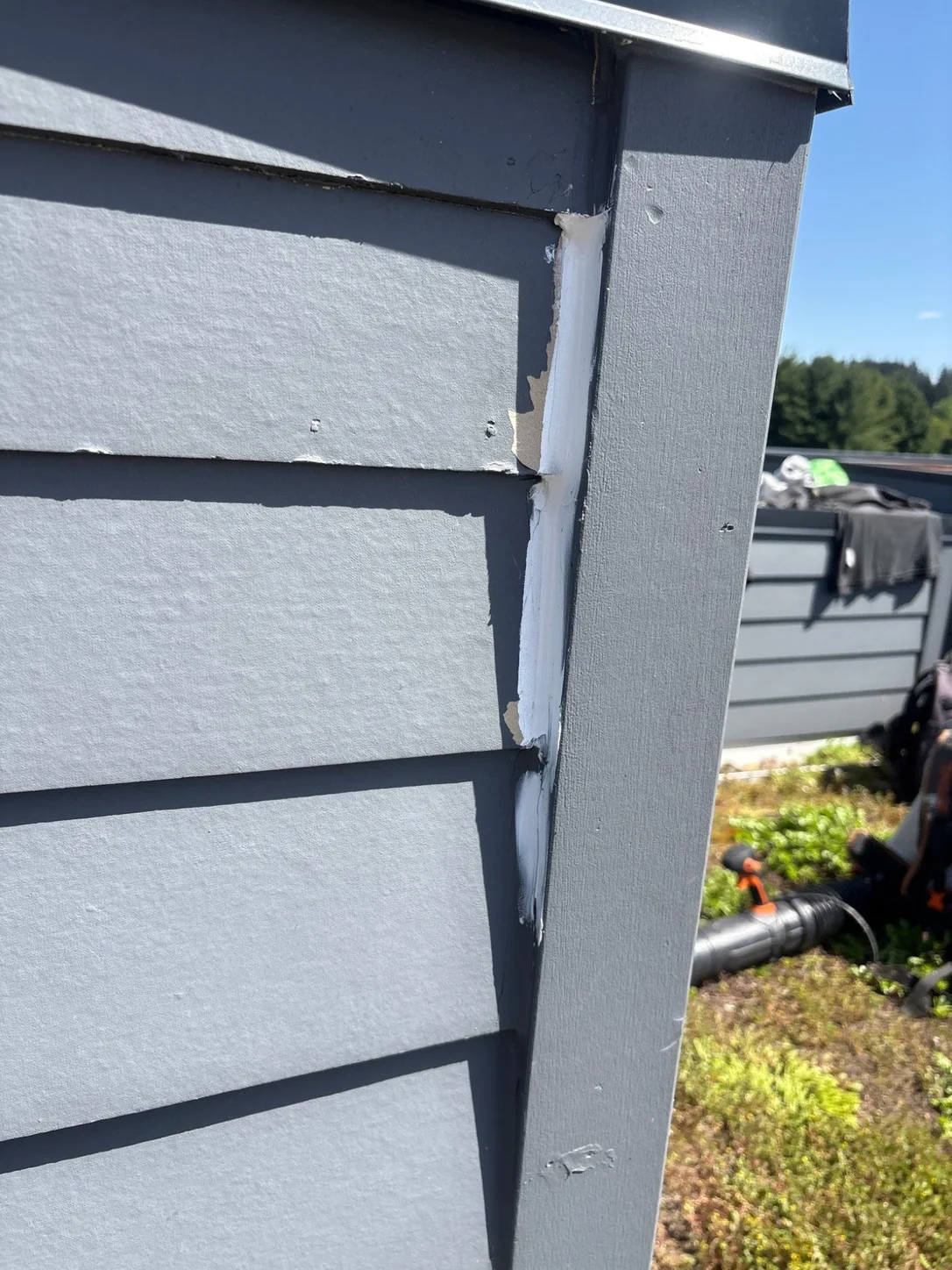 White sealant filling the gap where the siding meets the corner trim.