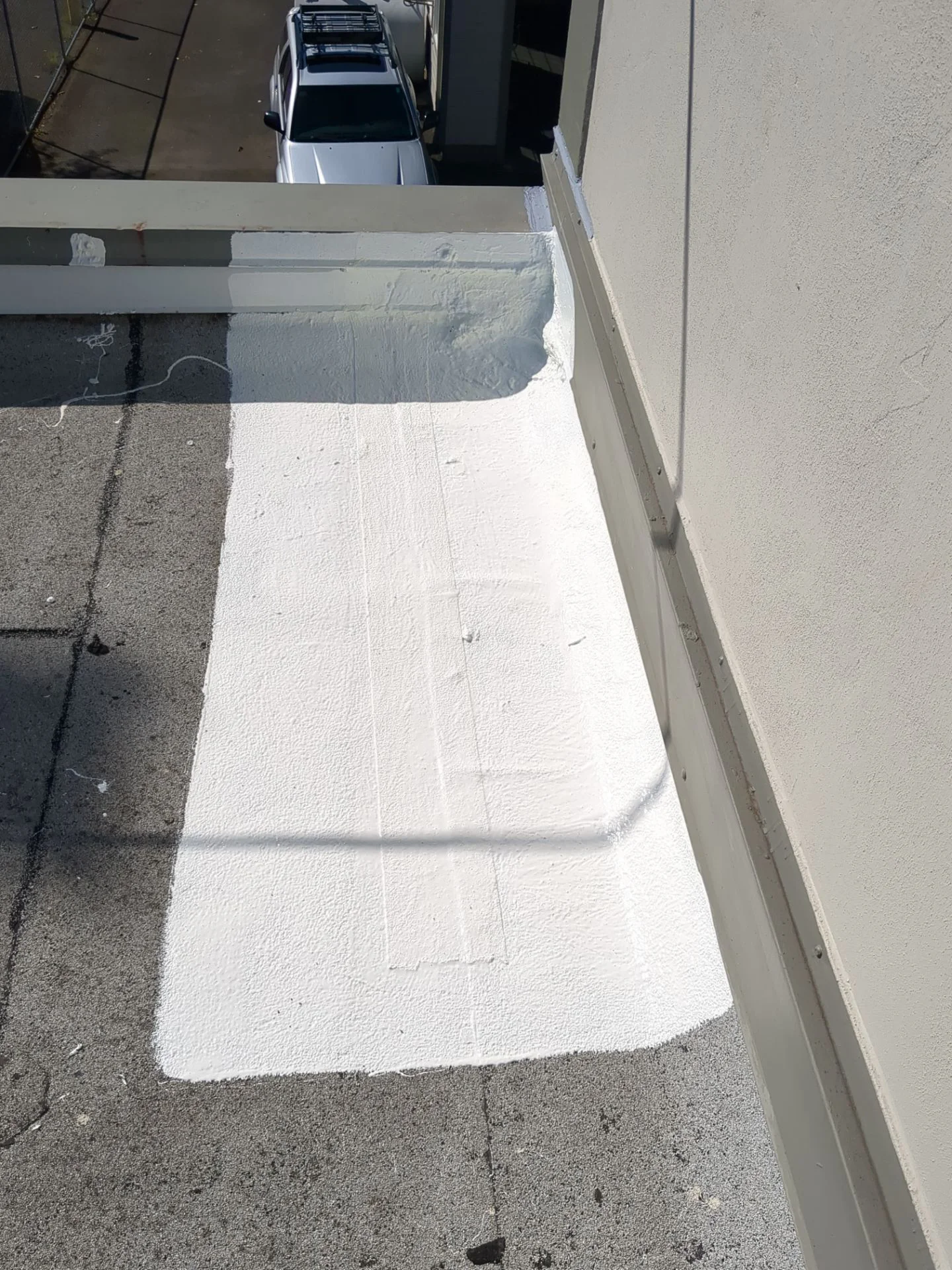 Silicone sealed into the corner where the roof meets the wall.