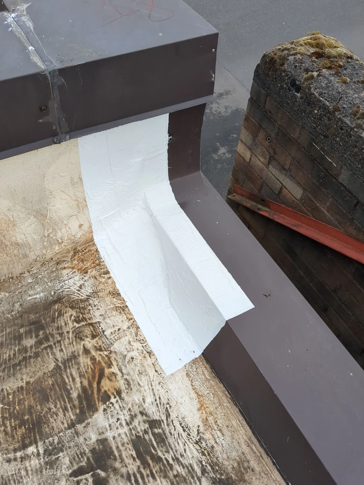 Membrane sealed over the lip at the roof's edge.