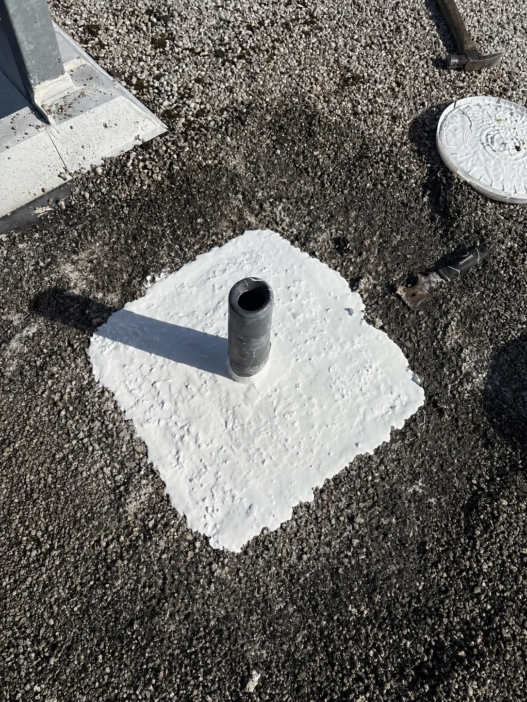 A pipe penetration sealed flush into the roof surface.