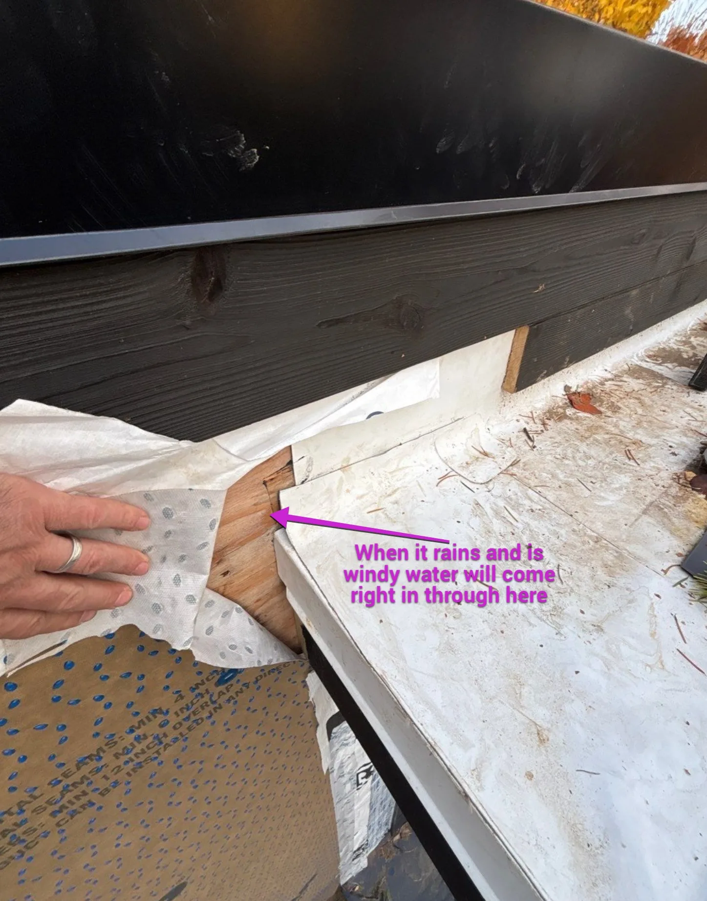 An annotated inspection photo showing a vulnerable roof edge where wind-driven rain can enter.